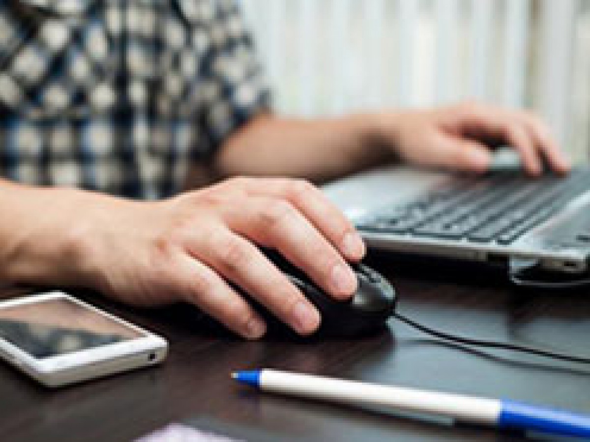 male typing at a laptop