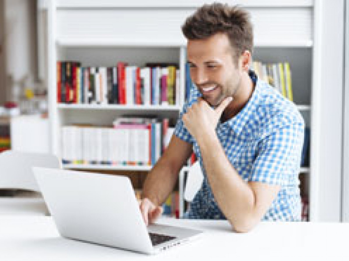 man smiling at laptop