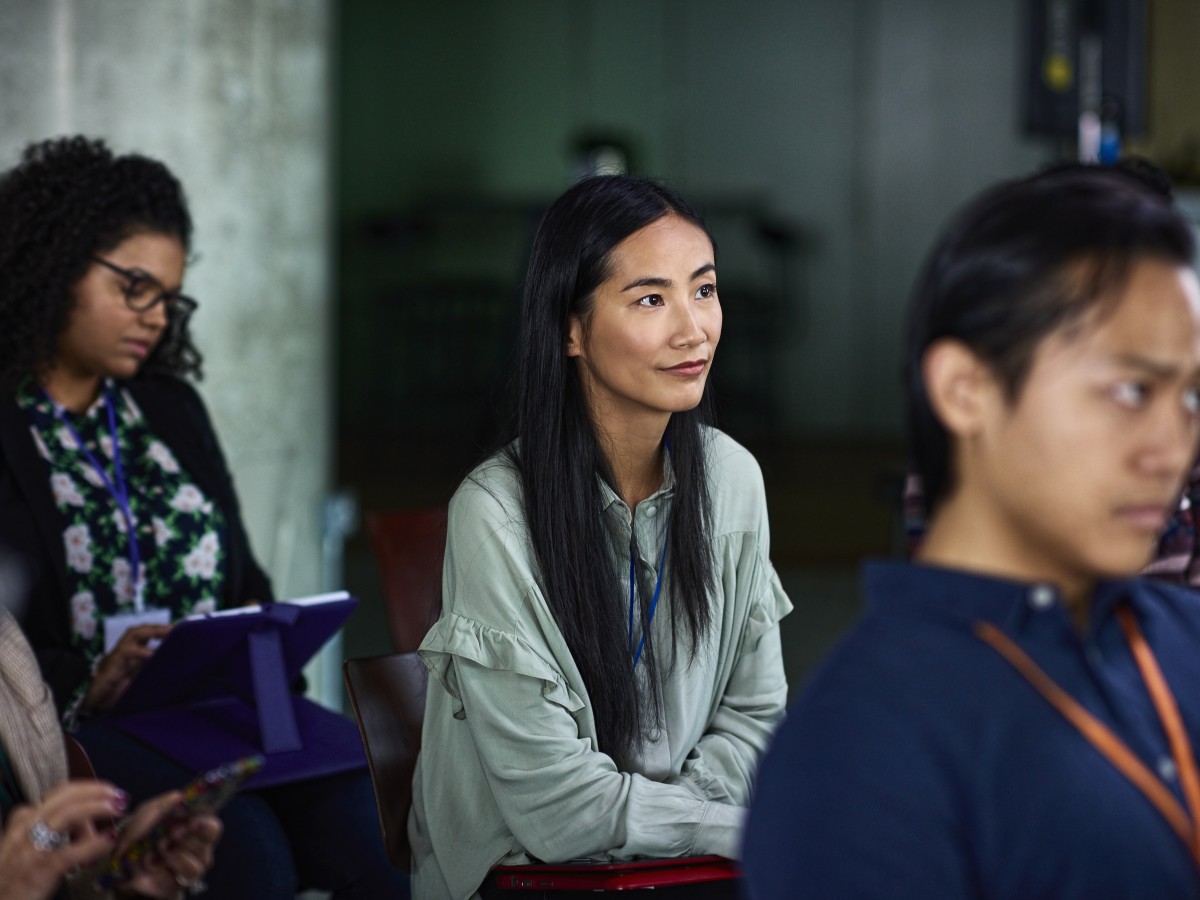 Young Asian woman listening at seminar