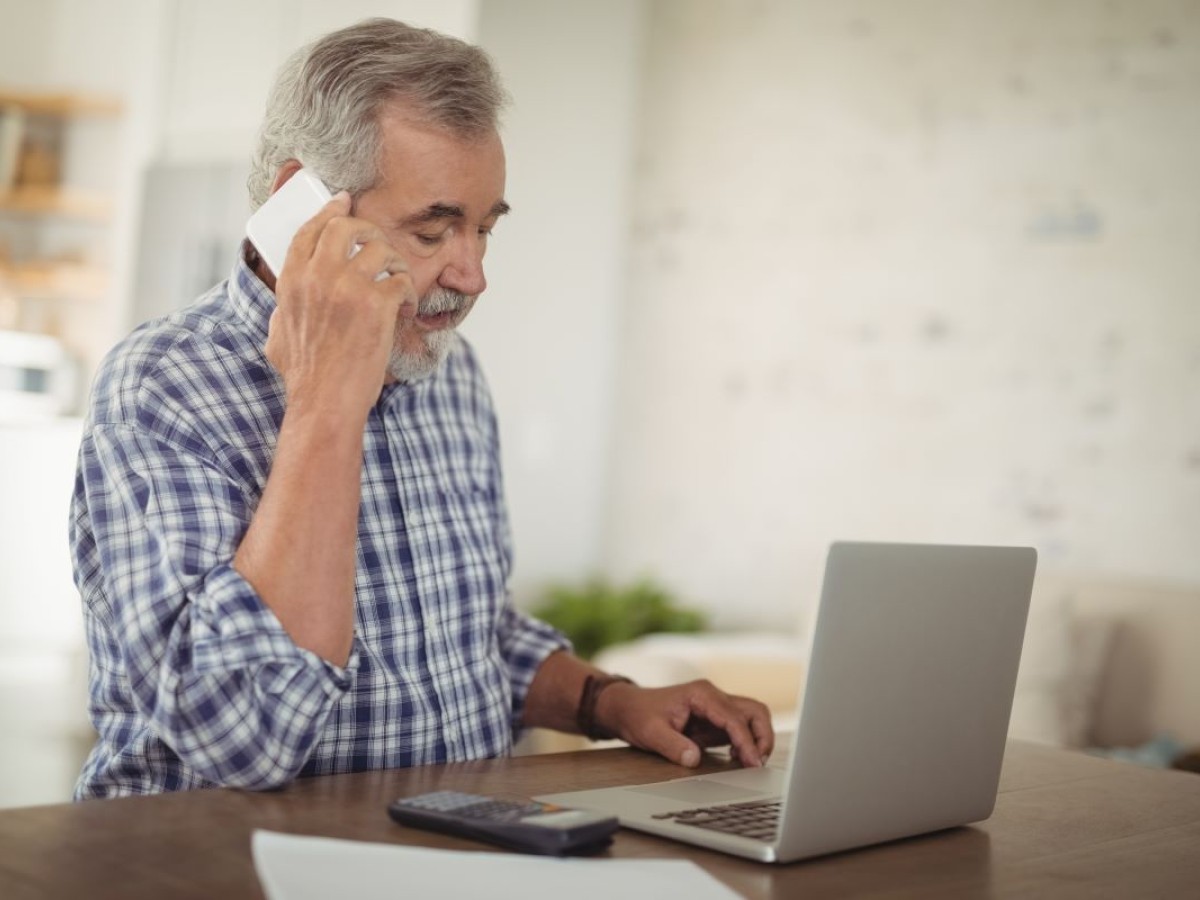 Senior man on phone and laptop