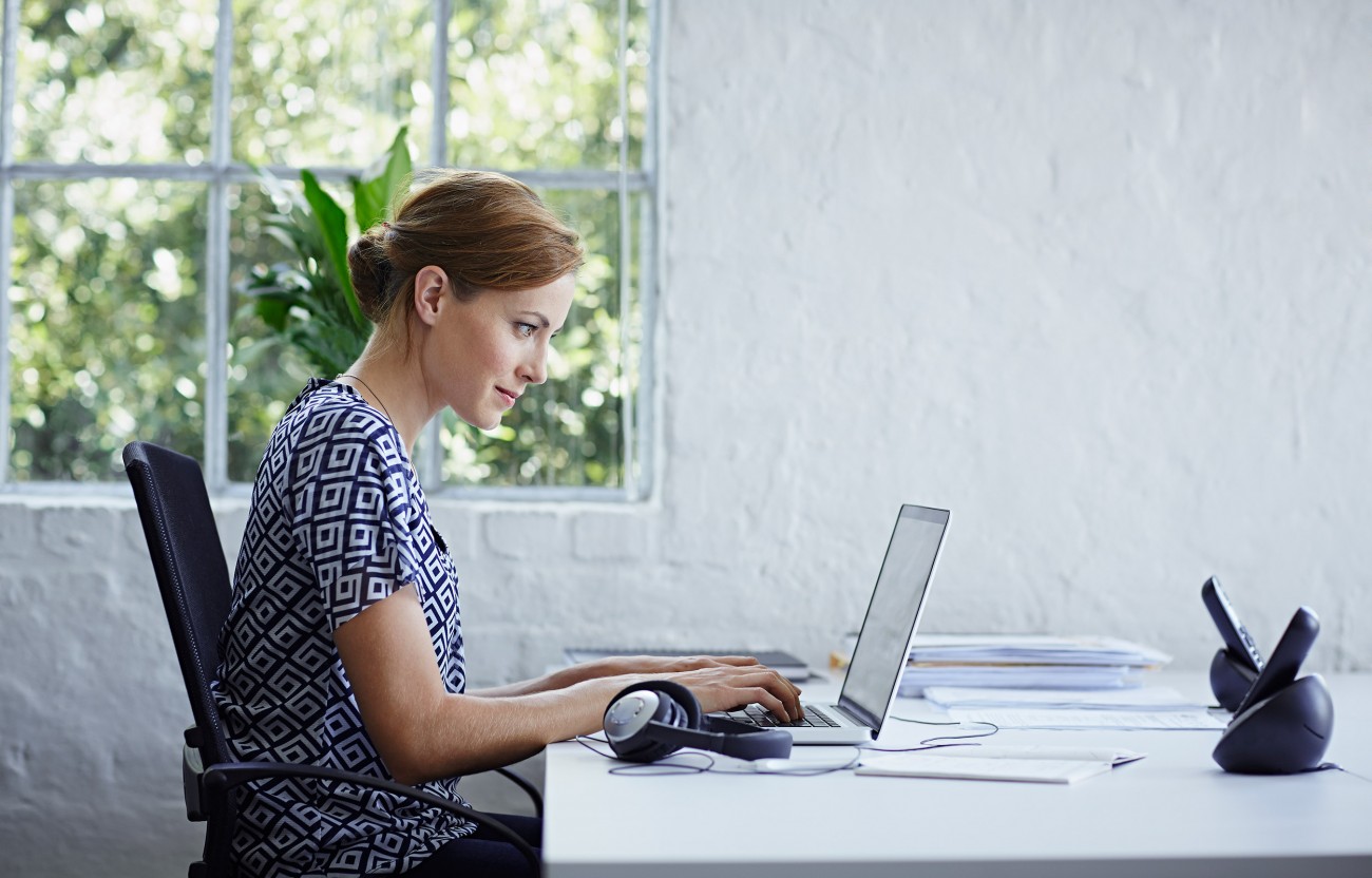 Woman sitting at desk in front of laptop