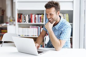 man smiling at laptop