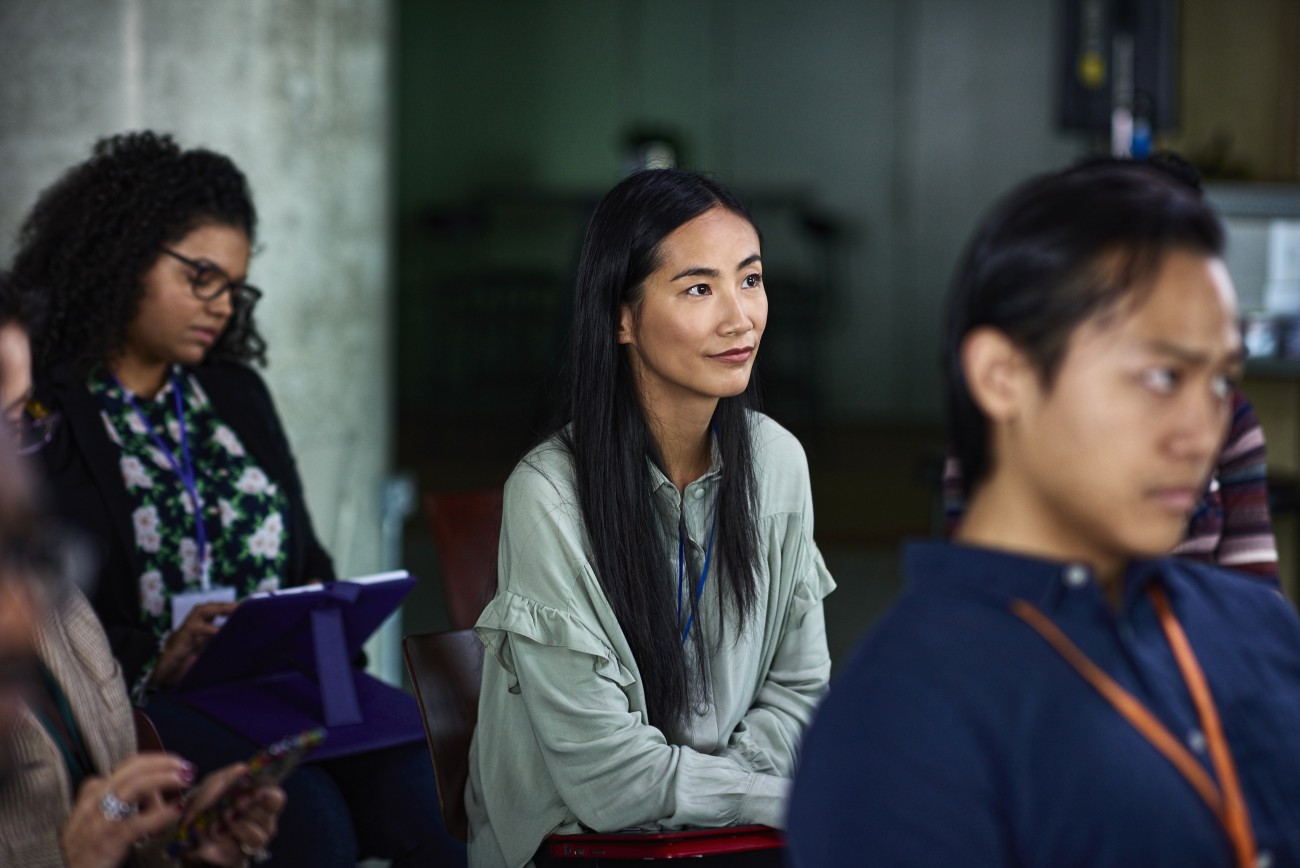 Young Asian woman listening at seminar