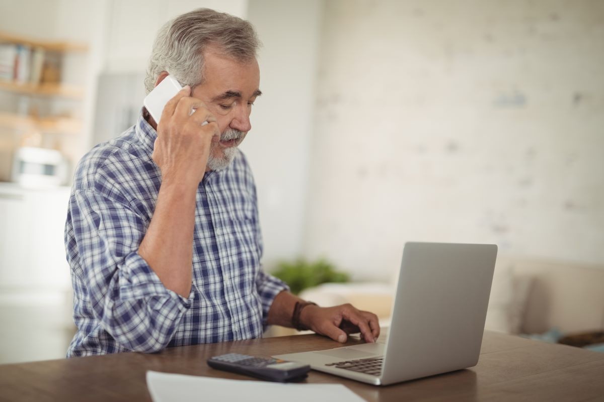 Senior man on phone and laptop