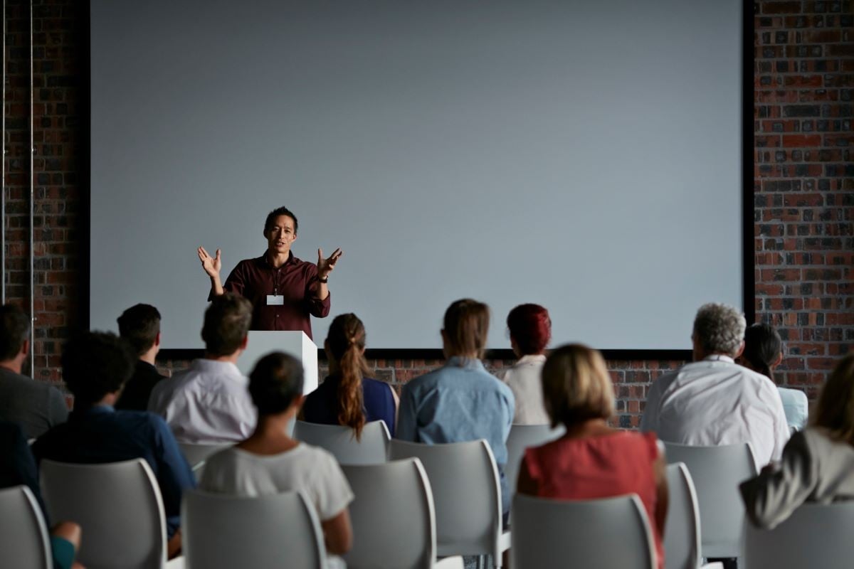 Event - Male speaker in front of a brick wall