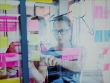 Woman pointing at paper notes taped to a window