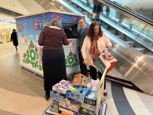 Photo of OSC staff bringing a dolly loaded with donated toys to a collection point