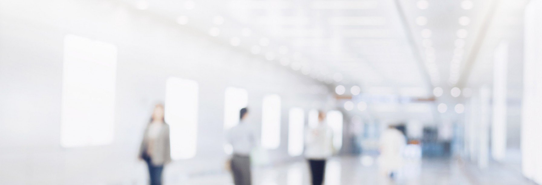 Blurry view of people walking in a long hallway