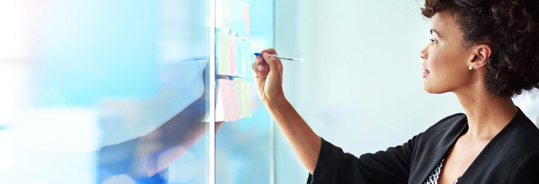 Woman writing on a glass board