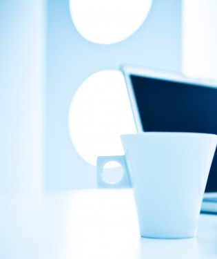 Coffee cup on desk with laptop