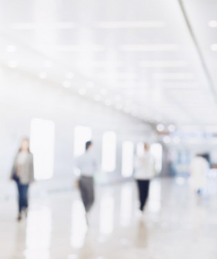 Blurry view of people walking in a long hallway