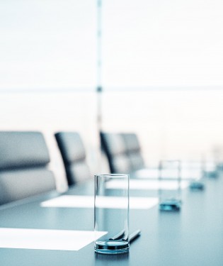 Empty boardroom with chairs and paper on the table