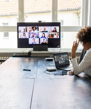 Woman sitting at a table watching a video conference call