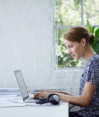 Woman sitting at desk in front of laptop