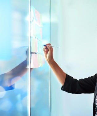 Woman writing on a glass board